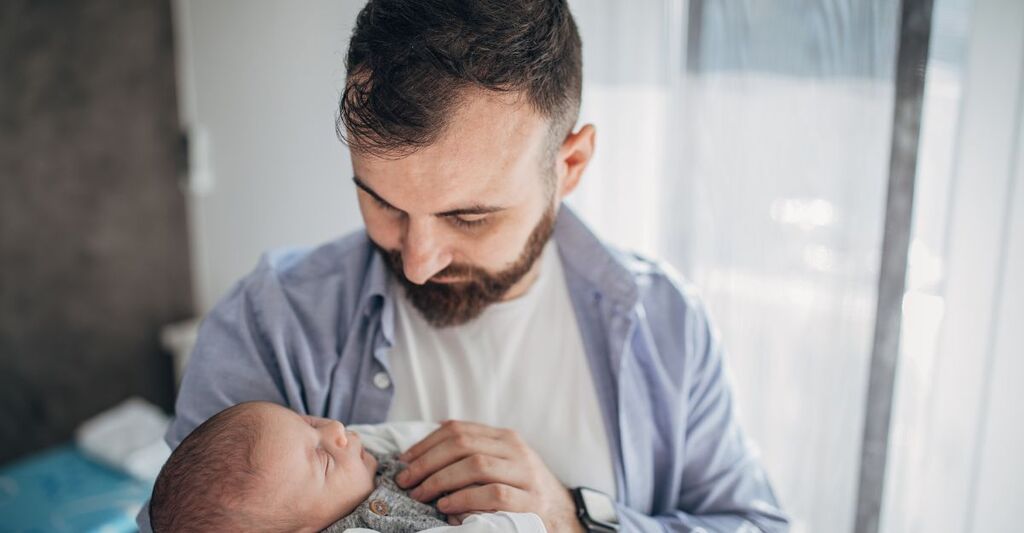 papà tiene in braccio neonato