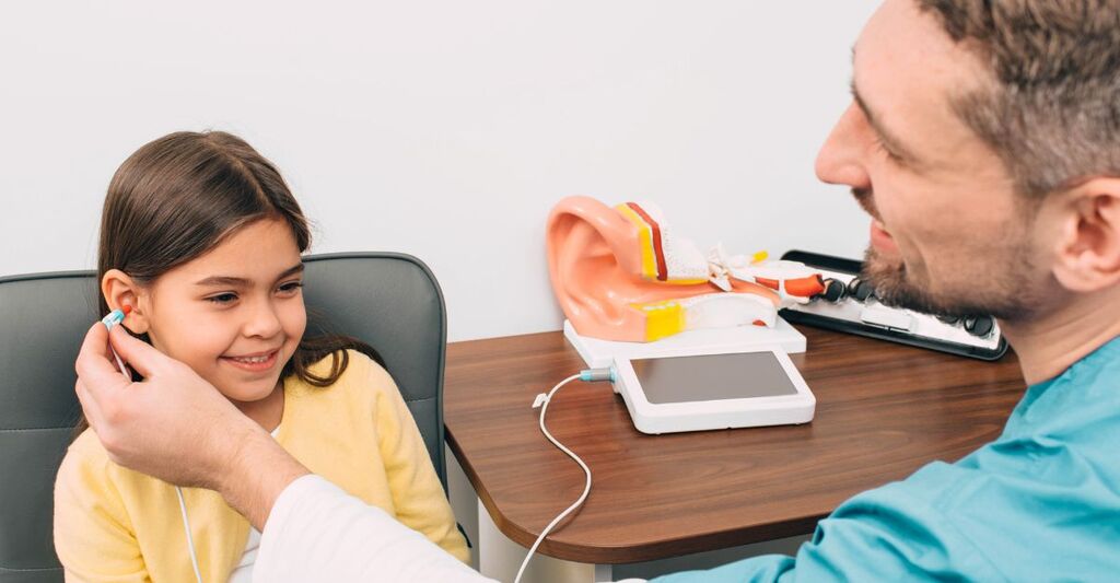 pediatra controlla l'udito ad una bambina