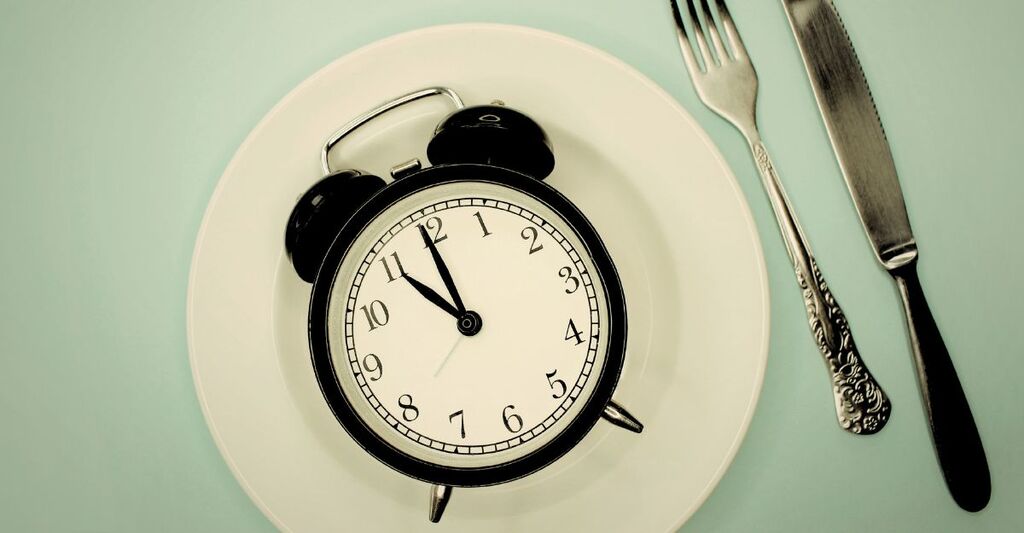 Un piatto con una sveglia utile alla cronodieta mediterranea.