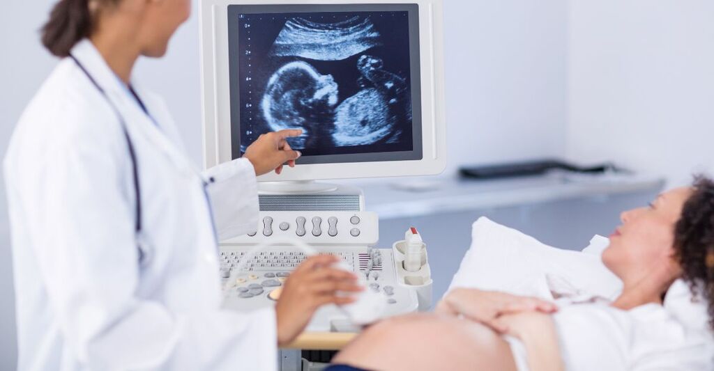 Medico che esegue un'ecografia su una donna incinta