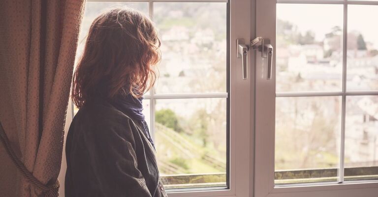 Una giovane davanti alla finestra in primavera.