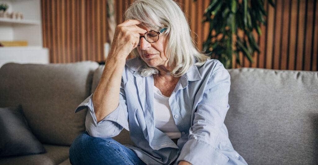 donna di 50 anni, si tiene la testa