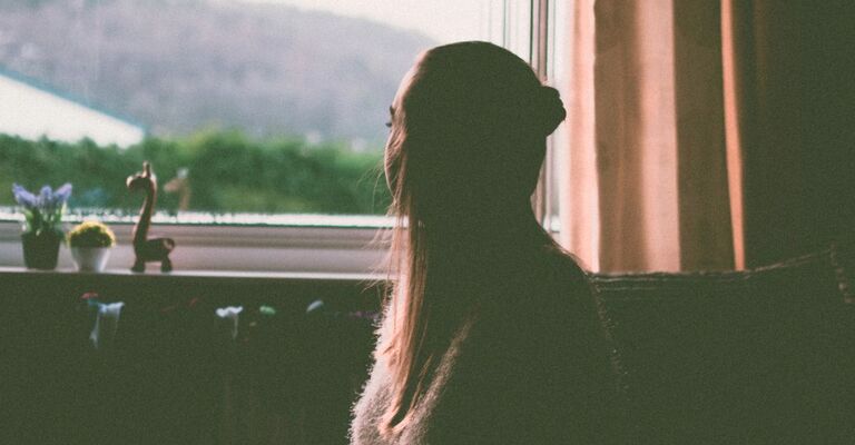 Una donna davanti alla finestra in primavera.