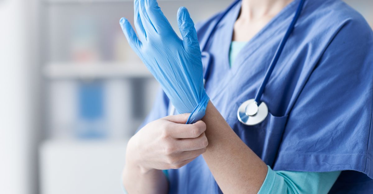 Un medico che si infila un guanto