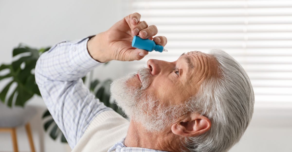 Un uomo che si mette un collirio