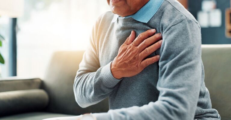 uomo si tocca il petto dolorante
