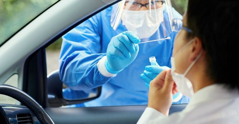 Un medico fa un tampone anticovid ad una persona in macchina