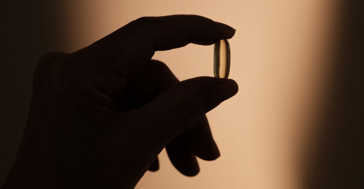 donna che tiene un integratore tra due dita