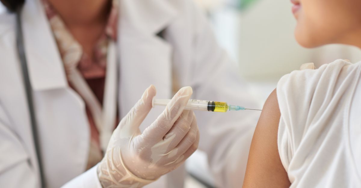 Primo piano di un medico con guanti che somministra un vaccino sul braccio di un paziente
