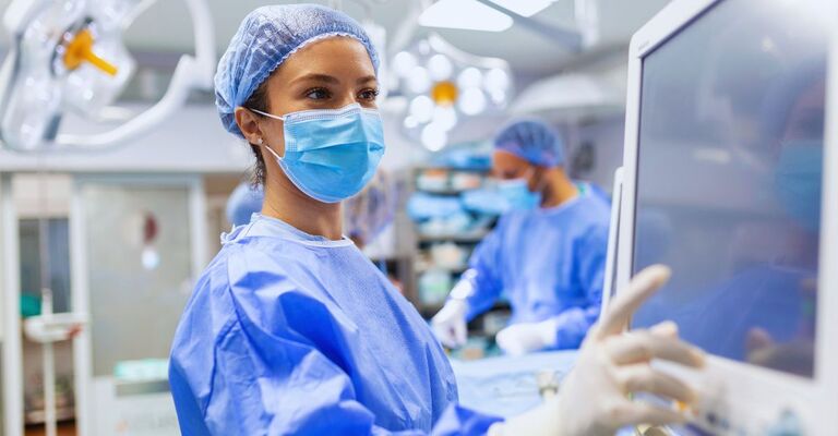 Un'équipe chirurgica concentrata sta operando un paziente in sala operatoria. Un anestesista altamente qualificato, con anni di esperienza nell'utilizzo di apparecchiature complesse, segue il paziente per tutta la durata dell'intervento.