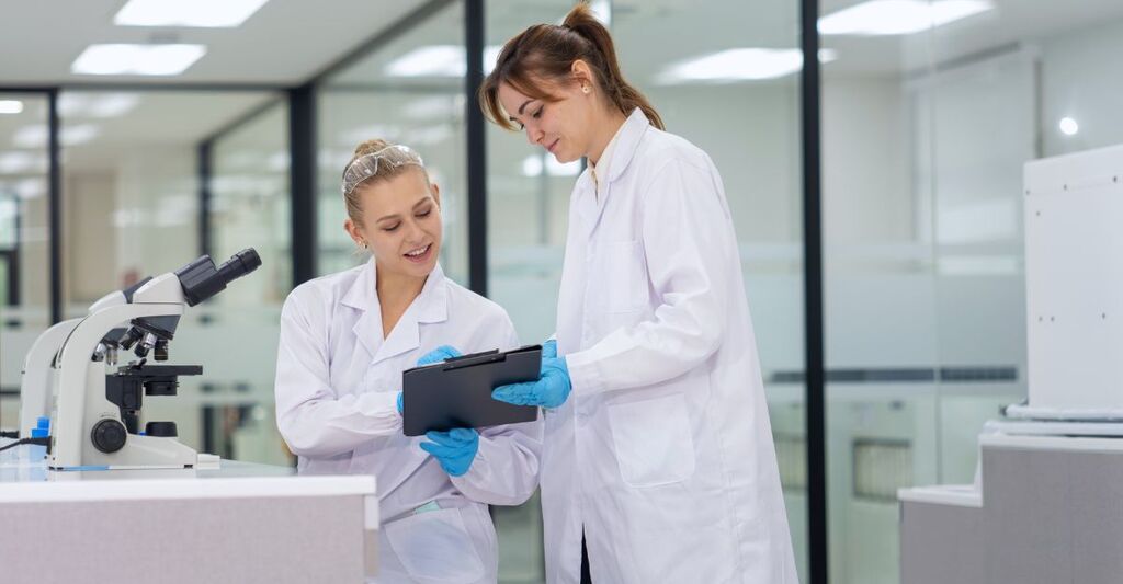 Nel pomeriggio, gli scienziati collaborano in un laboratorio moderno analizzando dati e discutendo i risultati delle ricerche.