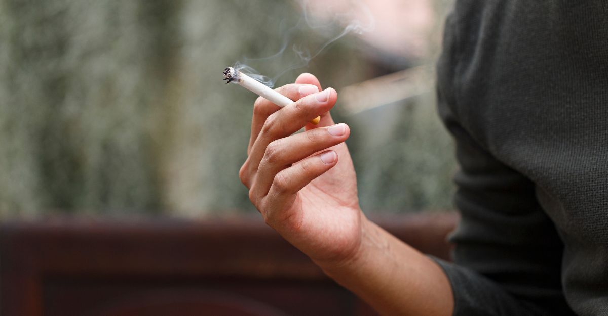 Uomo che tiene in mano una sigaretta fumante
