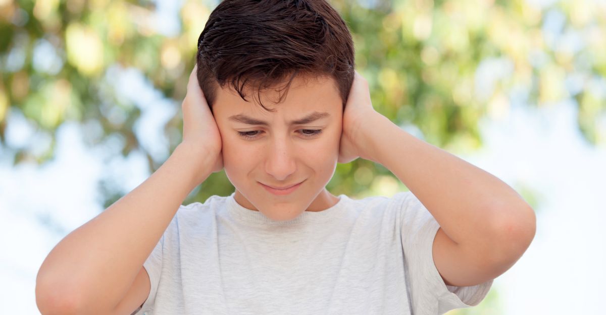 Un ragazzo che si tappa le orecchie