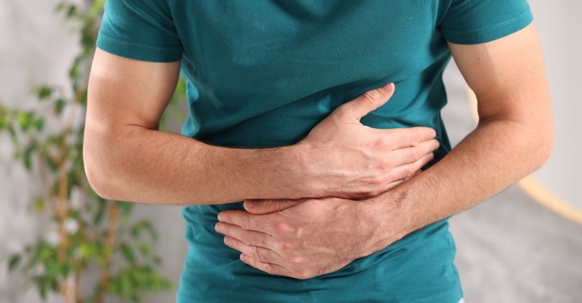 Un uomo si tiene la pancia dolorante