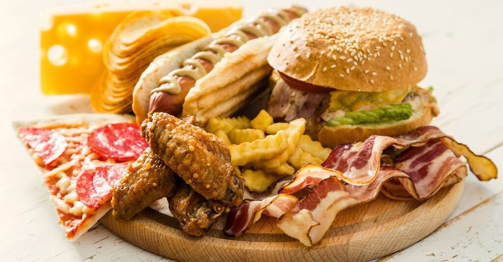 hamburger-pizza-patatine-fritte-bacon-su-un-tagliere