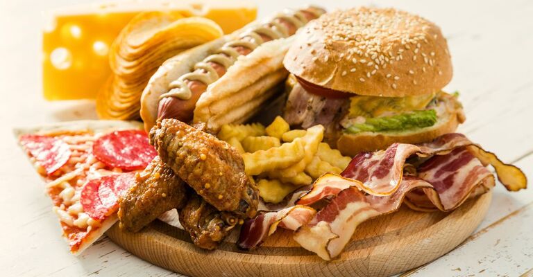 hamburger-pizza-patatine-fritte-bacon-su-un-tagliere