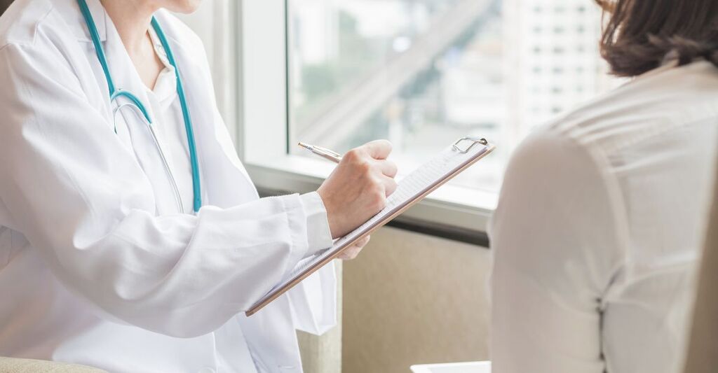 Un medico (ginecologo o psichiatra) visita e controlla la salute di una paziente in una clinica o in un centro di assistenza sanitaria ospedaliera.