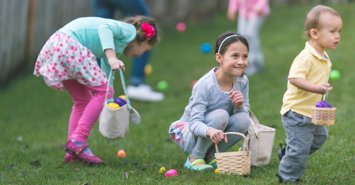 Bambini che partecipano a una caccia alle uova di Pasqua su un prato verde con i loro cestini