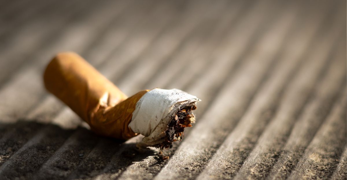 Primo piano di un mozzicone di sigaretta spento su una superficie ruvida e rigata