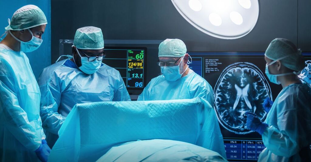 Un team eterogeneo di chirurghi professionisti esegue interventi chirurgici in sala operatoria utilizzando attrezzature all'avanguardia. I medici lavorano per salvare un paziente in un ospedale moderno. Medicina, tecnologia e assistenza sanitaria.