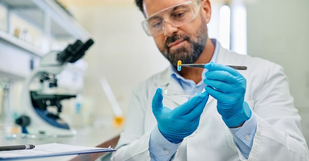 Primo piano di uno scienziato intento a sviluppare un nuovo farmaco durante una ricerca in un laboratorio farmaceutico.