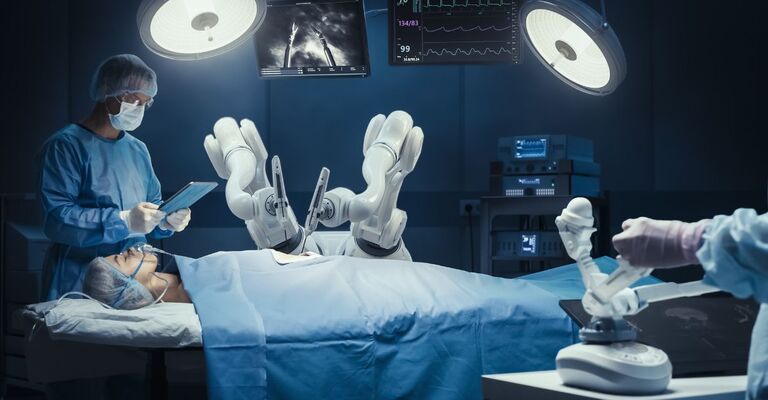 Chirurgo con visore per realtà aumentata, utilizza bracci robotici ad alta precisione controllati a distanza per operare un paziente, mentre il suo collega controlla i parametri vitali su un tablet in ospedale. Medici al lavoro con arti robotici.