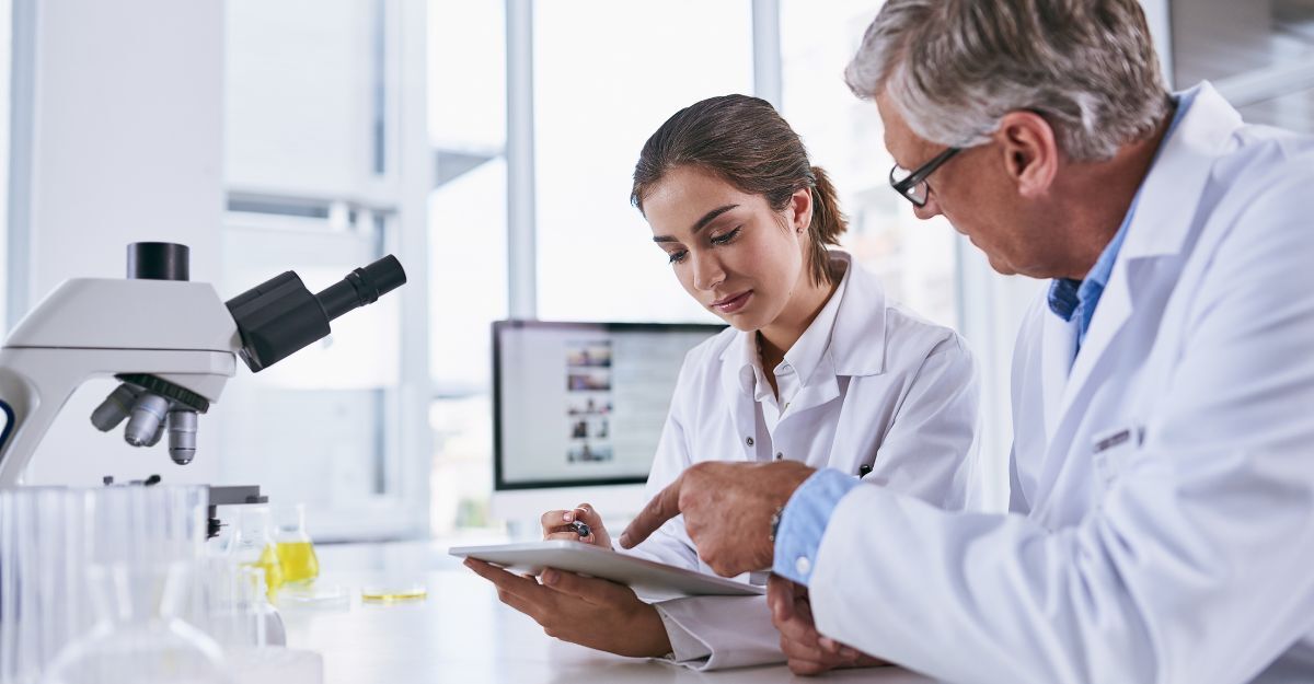 Scienziato, tablet e team di esperti in scienze forensi che esaminano i risultati di un esperimento o collaborano in laboratorio. Donna e uomo impegnati nella ricerca medica lavorano su tecnologie per la ricerca scientifica in laboratorio.