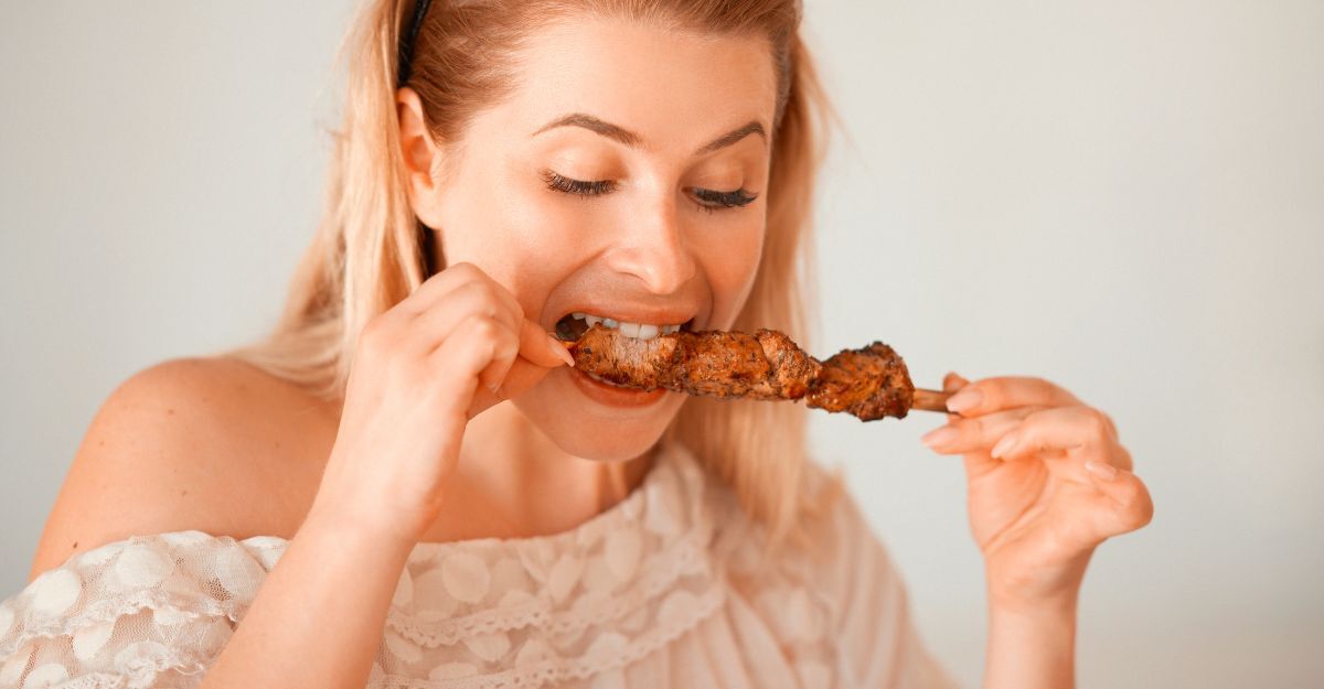 Una donna mangia troppa carne.