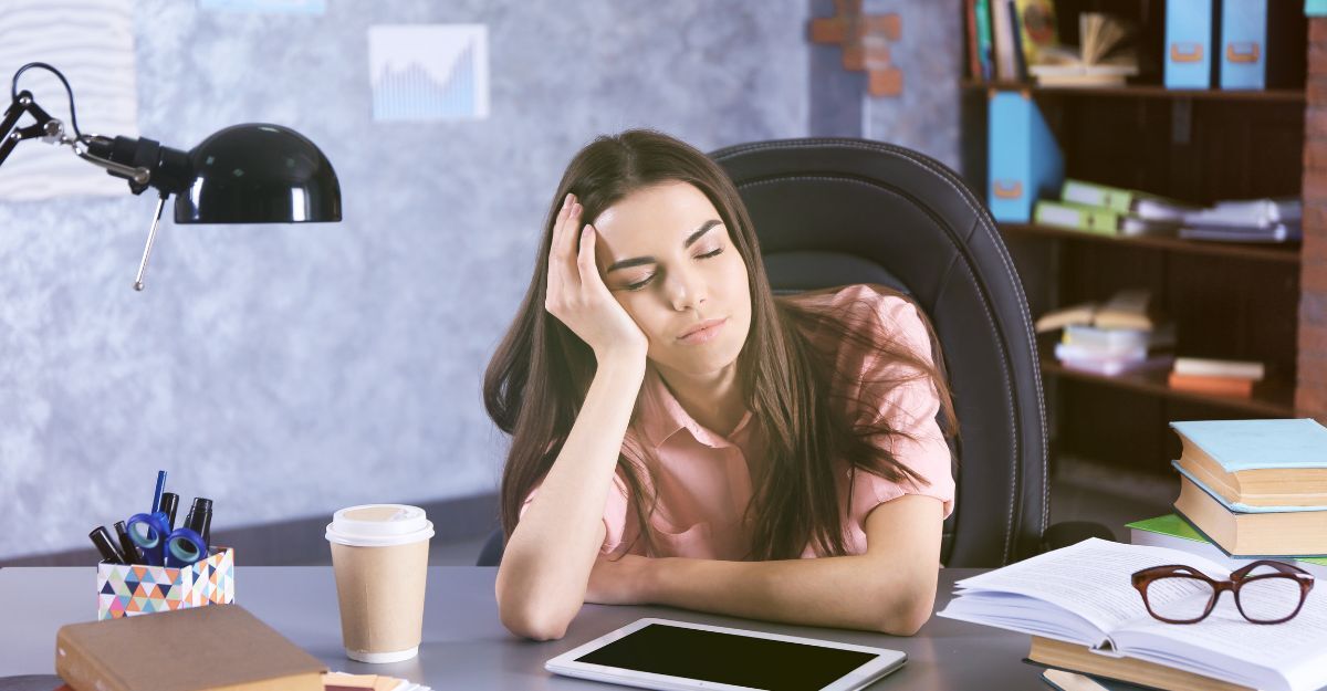 ragazza seduta alla scrivania, assonnata