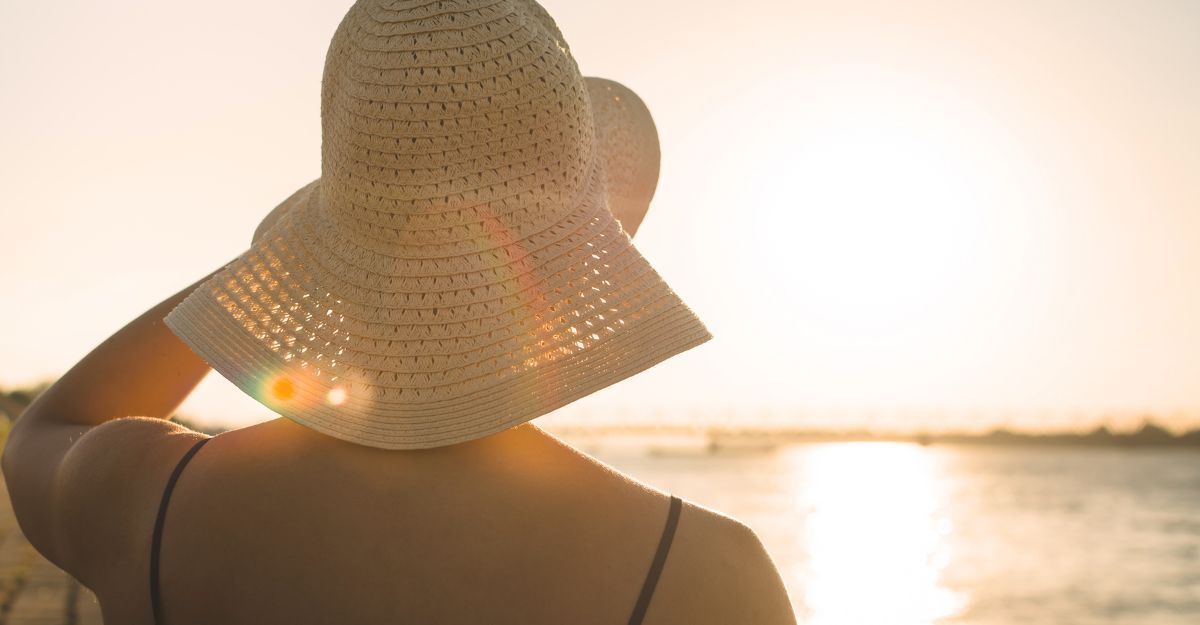 Una donna guarda il tramonto sul mare