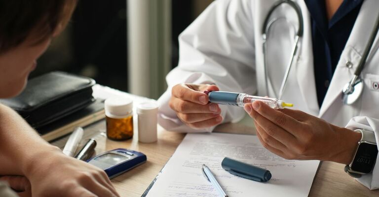 Un medico spiega come usare una penna per insulina.