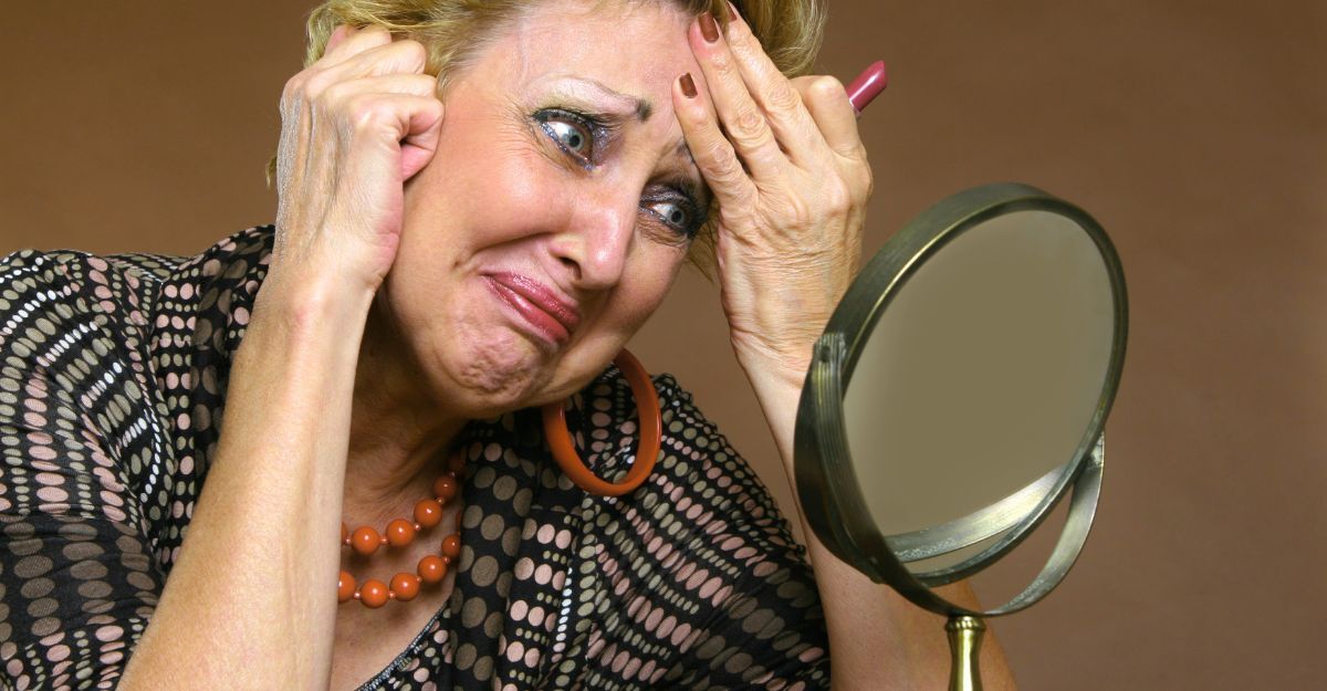 Una donna si guarda allo specchio per capire se sta invecchiando più velocemente del suo corpo e si spaventa.
