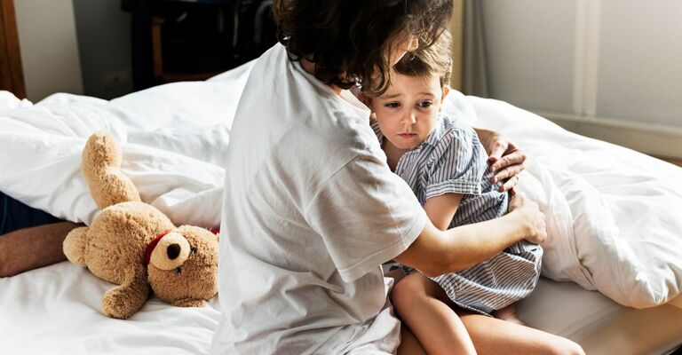 La madre consola il figlio piccolo nel letto dopo un incubo
