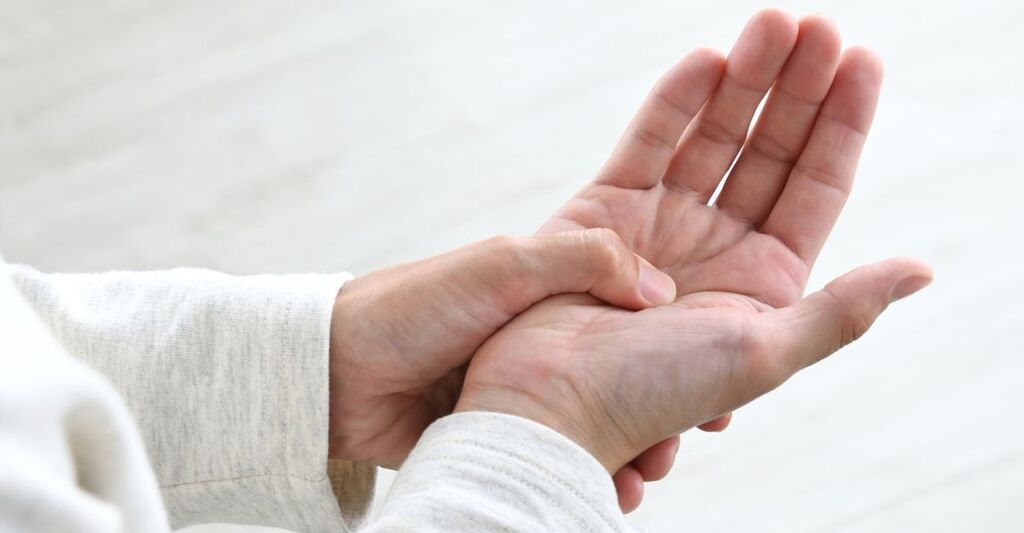 Il primo piano di un signore che si tiene una mano tremante