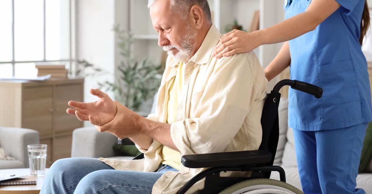 Un signore in carrozzina che si tiene una mano tremante