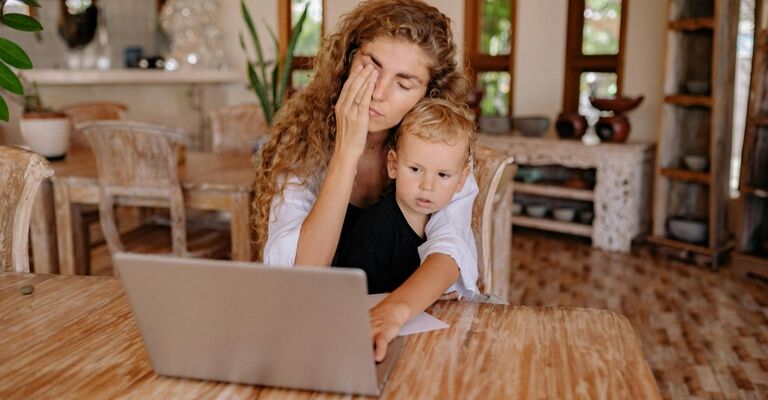 mamma stanca che lavora al pc, con bimbo in braccio
