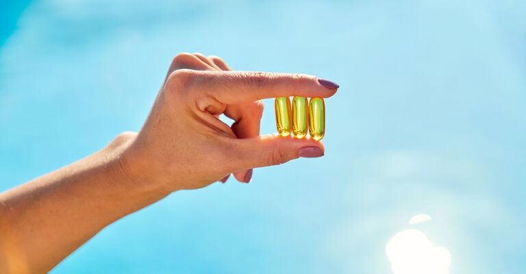 donna-che-tiene-tre-capsule-di-vitamina-D