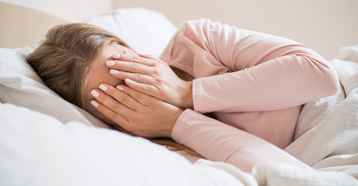 donna nel letto, si copre il volto con le mani