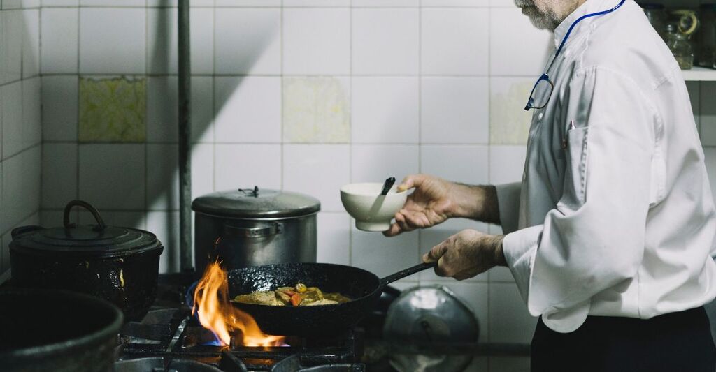 Un uomo anziano che cucina.