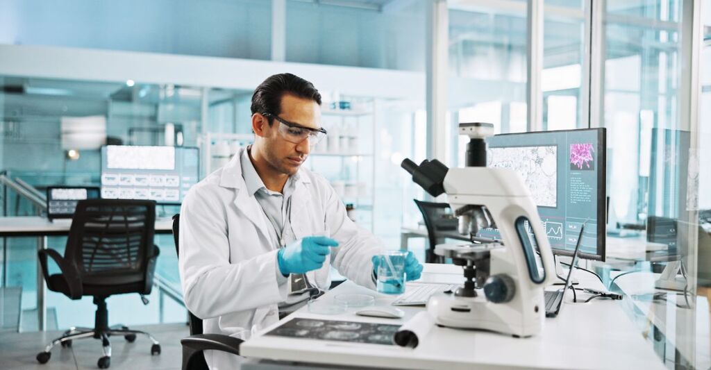 Microscopio, becher e ricerca con un uomo in laboratorio per un campione chimico, cura del cancro e assistenza sanitaria. Trattamento cellulare, referto e test medico con una persona in clinica per l'enzima tumorale e la registrazione.