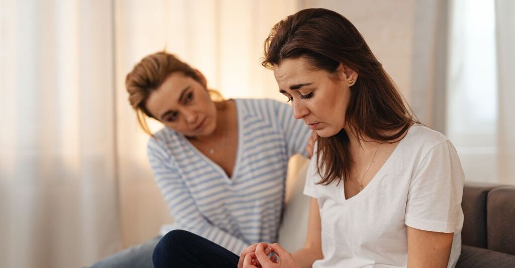 Una donna che presta sostegno ad un'altra ragazza