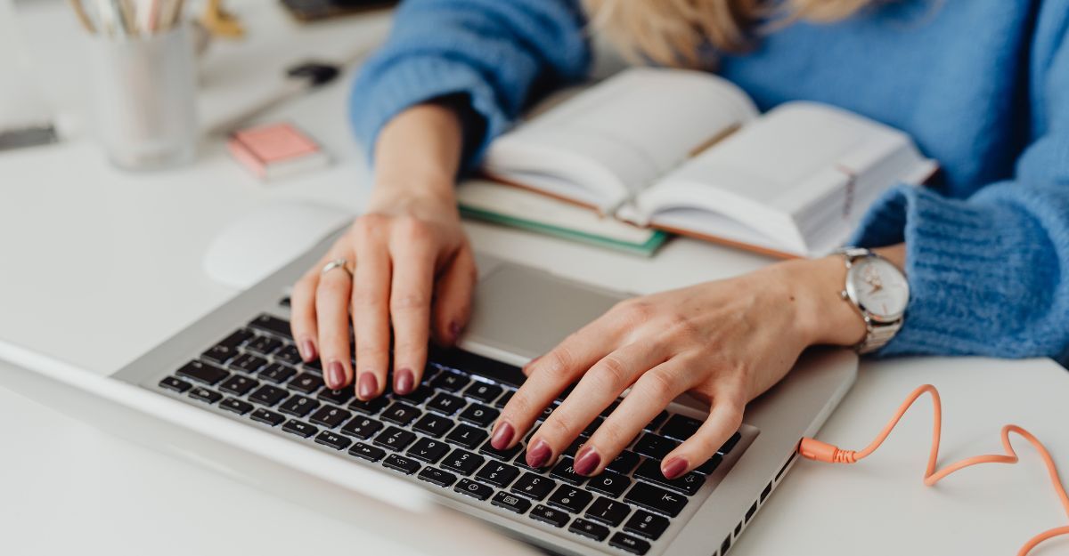 Il primo piano delle mani di una donna al computer