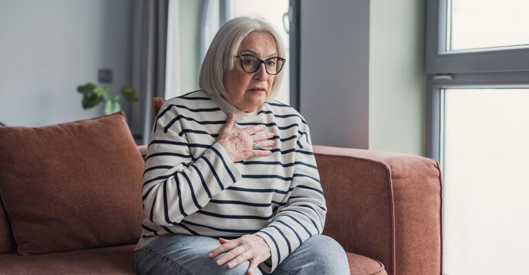 donna seduta sul divano, in affanno
