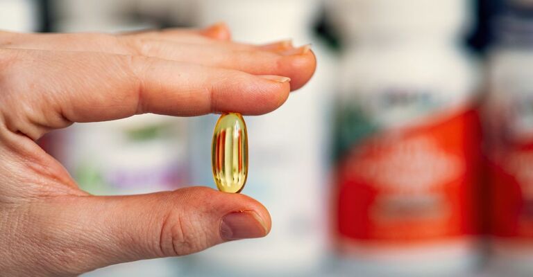 persona-che-tiene-capsula-di-vitamina-d
