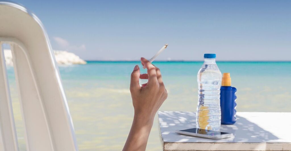donna fuma sigaretta in spiaggia