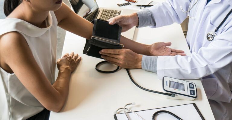 Un medico che prova la pressione ad una paziente