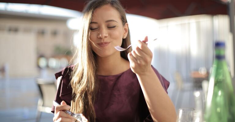 ragazza a tavola, mangia soddisfatta