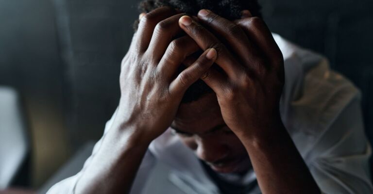 Una persona triste con le mani nei capelli