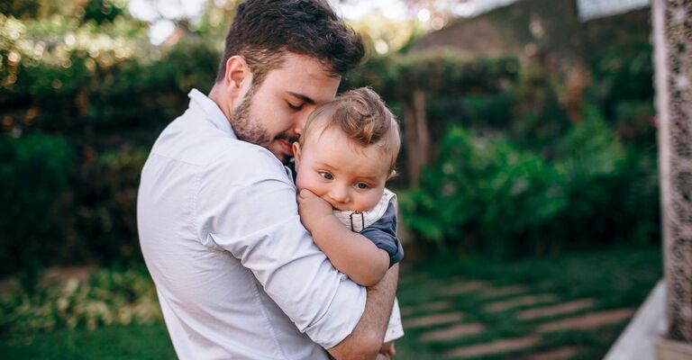 papà tiene in braccio bambino