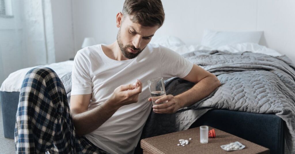 uomo triste prende farmaco